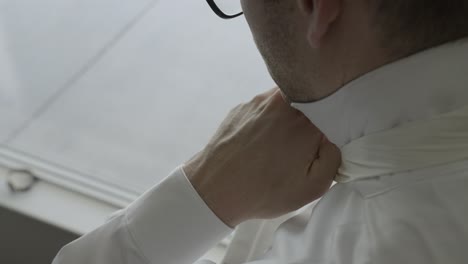 groom tying his tie