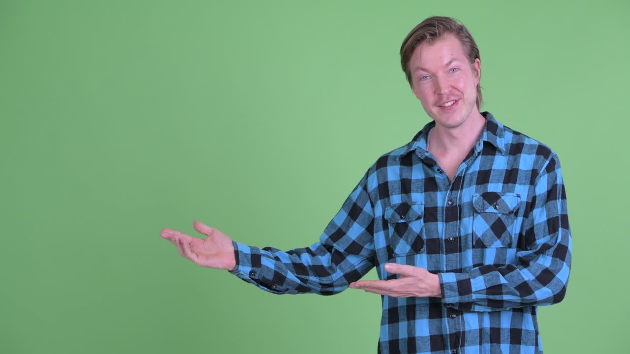retrato de un hombre caucásico sonriendo y mostrando el espacio de copia disparado contra el fondo verde del estudio