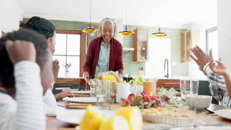 Fröhliche-Afroamerikanische-Mehrgenerationenfamilie,-Die-Essen-Beim-Thanksgiving-Dinner-Serviert,-Zeitlupe