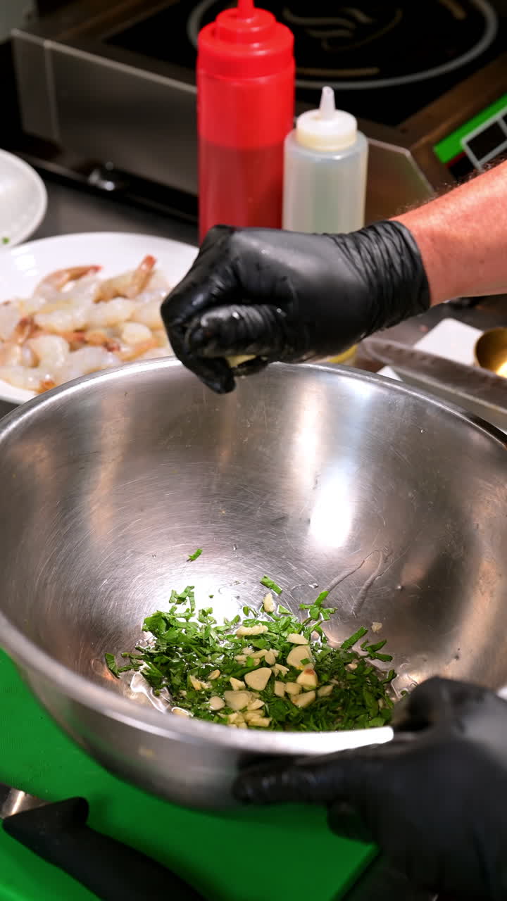 Garlic and herbs in bowl preparation. Fresh chopped garlic and parsley prepared in a metal bowl for cooking