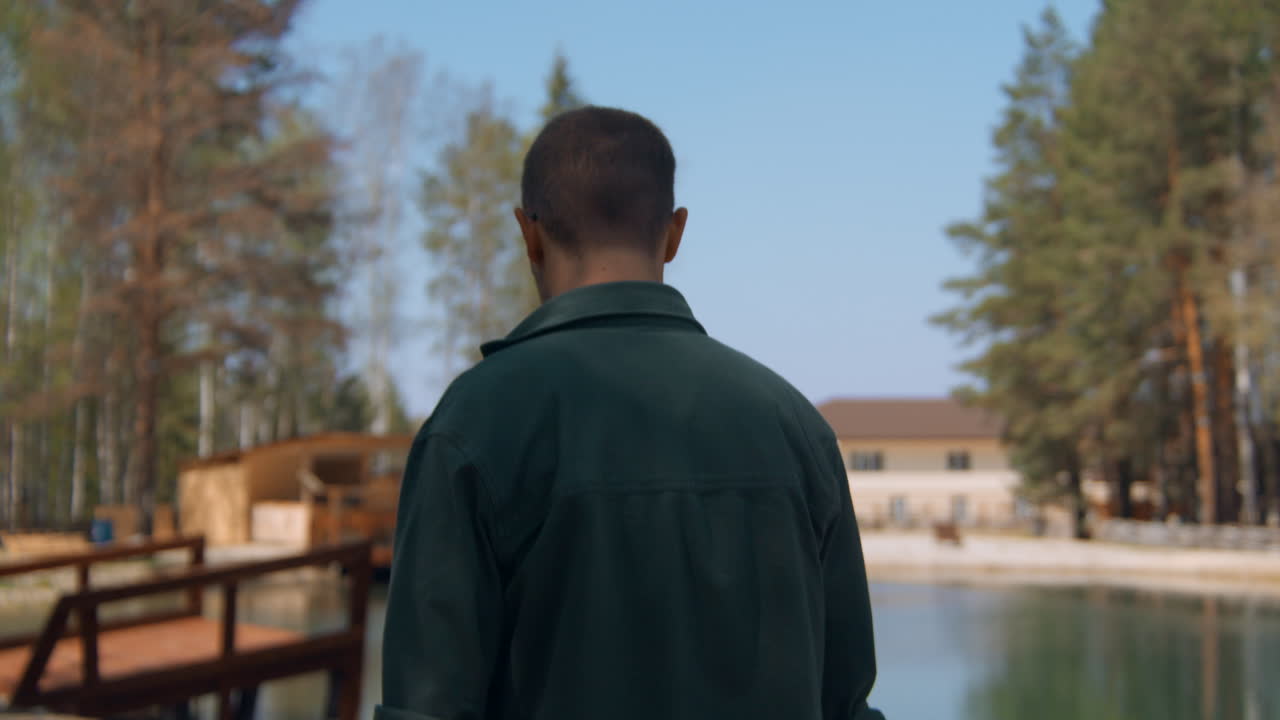 Man Walking in a Forest by a Lake