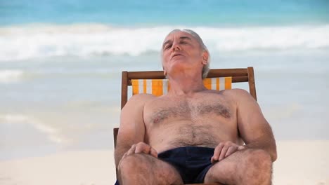 man relaxing lying on beach chairs