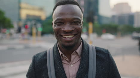 portrait of confident young african american businessman laughing enjoying successful lifestyle on busy urban city street