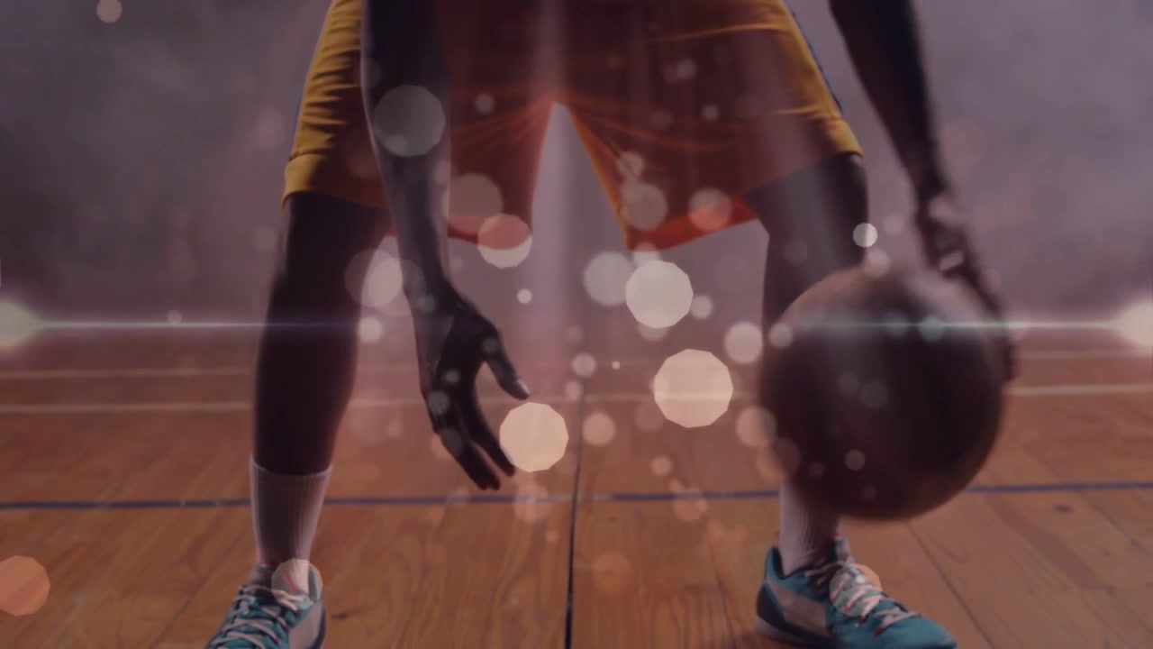 Male athlete starting dribble on landing, practicing basketball crossover, bokeh obscuring player