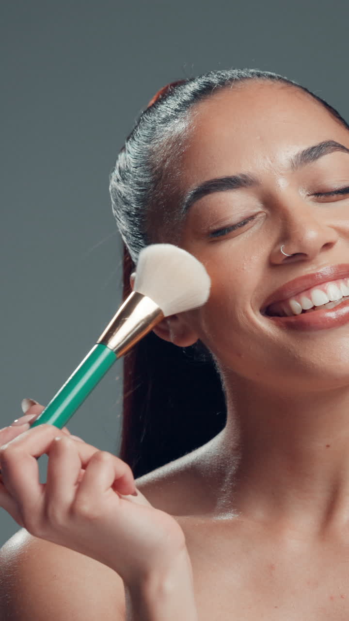 Smiling Woman Applying Makeup with a Brush to Her Cheek