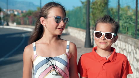 smiling children enjoying summer outdoor. cheerful teenagers speaking in street.