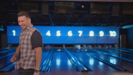 portrait caucasian man jumps joyfully looking into the camera celebrate the victory in slow motion. throw in the bowling alley to make a shoot. victory dance and jump with happiness.