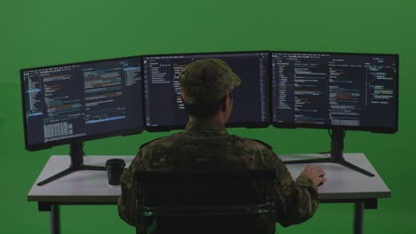 back view of happy asian man soldier developer celebrating and dancing while write code with multiple computer screens in green screen studio