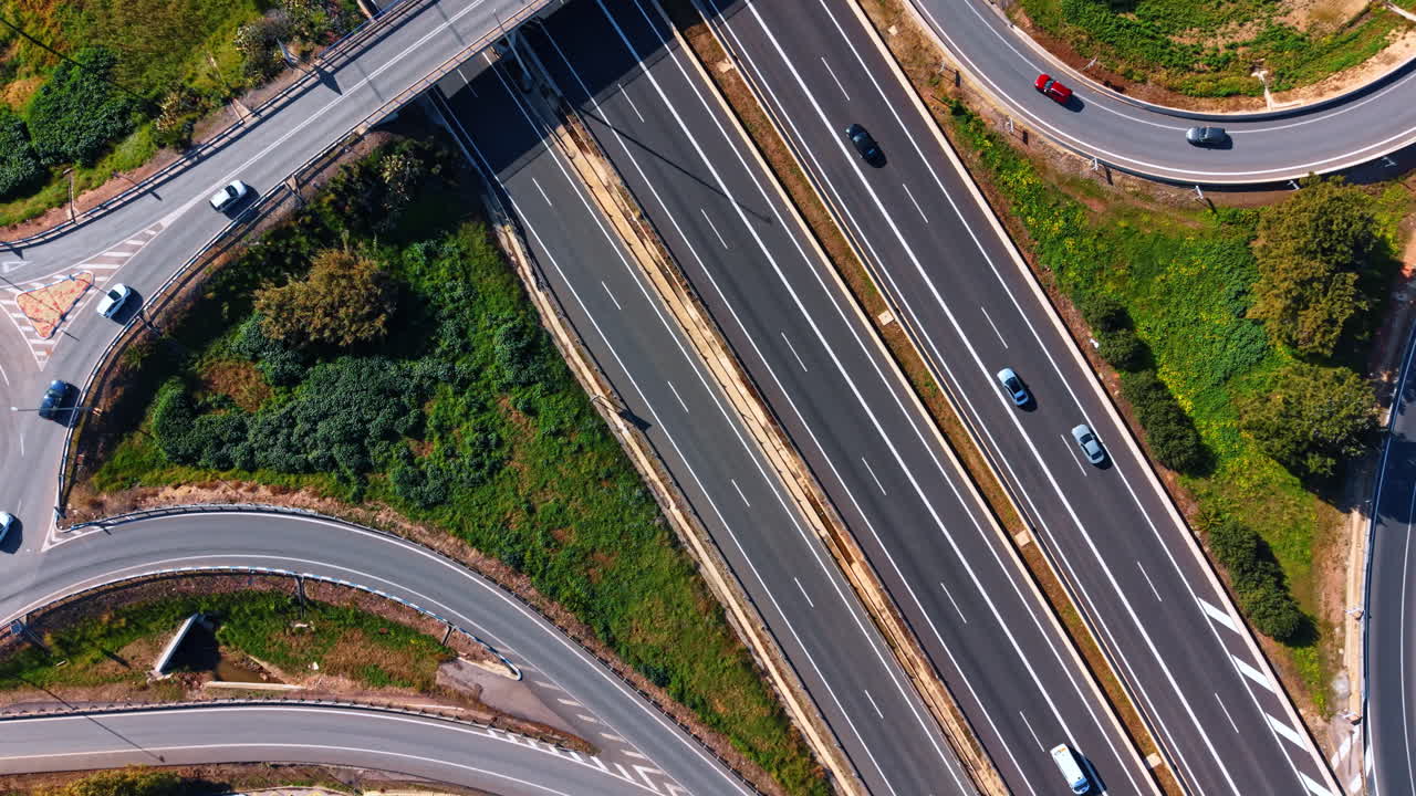Incrocio Autostradale e Paesaggio Verde. Ripresa Aerea Verticale di un'Autostrada a Più Corsie con Auto, Segnaletica Stradale e Aree di Erba Verde