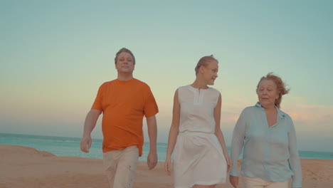 young woman and parents walking on beach