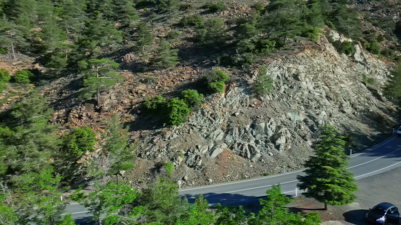 coche conduciendo por la carretera a través de un bosque en una montaña