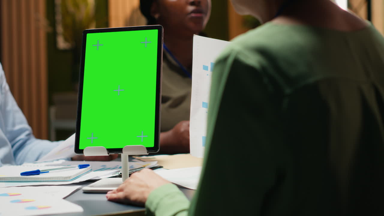 Business colleagues meeting late in the office with green screen tablet
