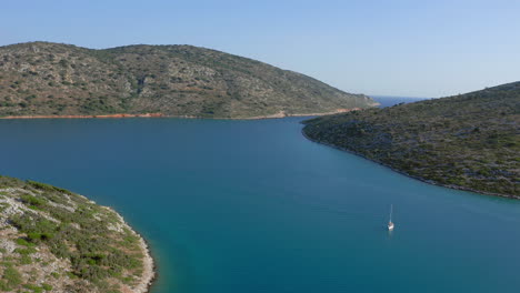 aerial: flying towards the entrance passage of planitis bay in kira panagia island, sporades, greece