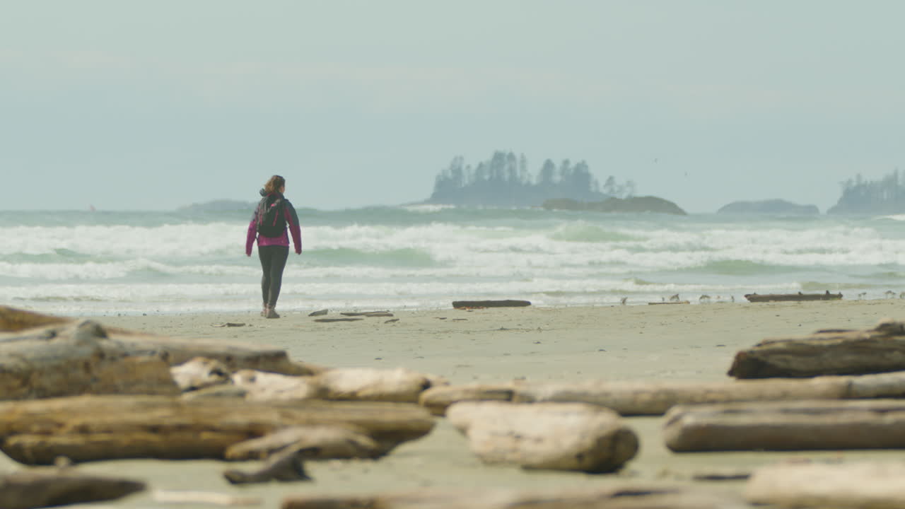 mujer caminando sola en long beach, borde del pacífico, canadá