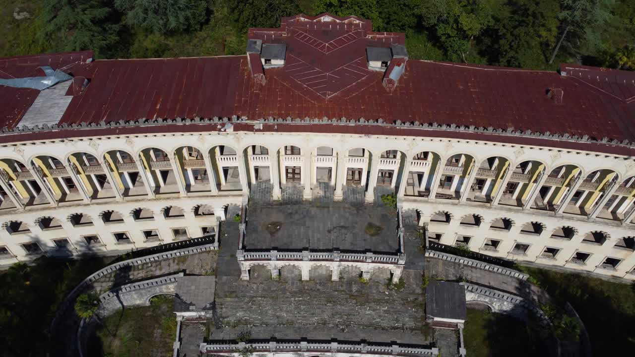 Aerial top of circular abandoned spa structure surrounded by forest in Tskaltubo, Georgia