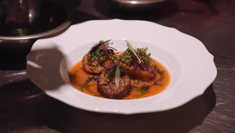 Close-up-panning-shot-of-a-delicious-Italian-dish-prepared-by-the-cook-on-a-round-white-plate