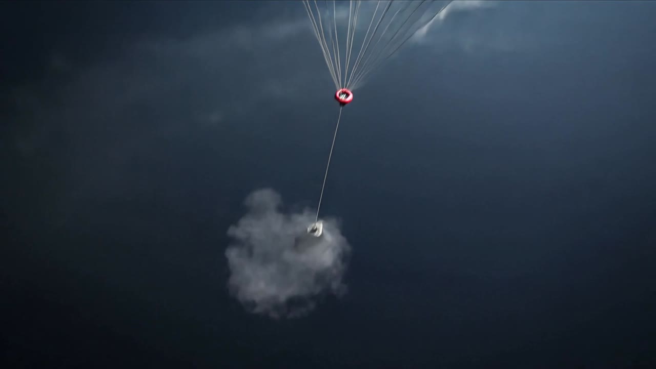 Carico utile aerospaziale metallico ancorato, sospeso contro il cielo, la telecamera si allontana rivelando un pallone rosso