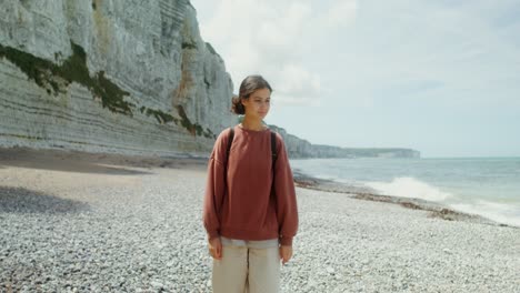 woman walking on a beach near cliffs