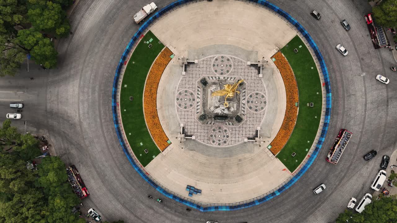 Aerial perspective of Angel of Independence monument adorned with marigold decorations at its base
