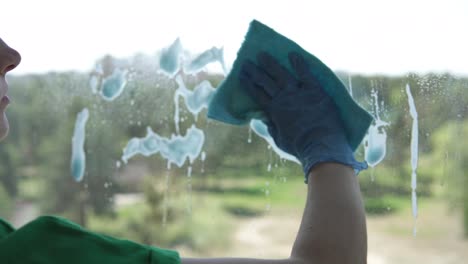 trabajador de la empresa de limpieza o ama de casa limpiando ventanas usando detergente y paño para limpiar ventanas. lavando ventanas con una botella de pulverización.