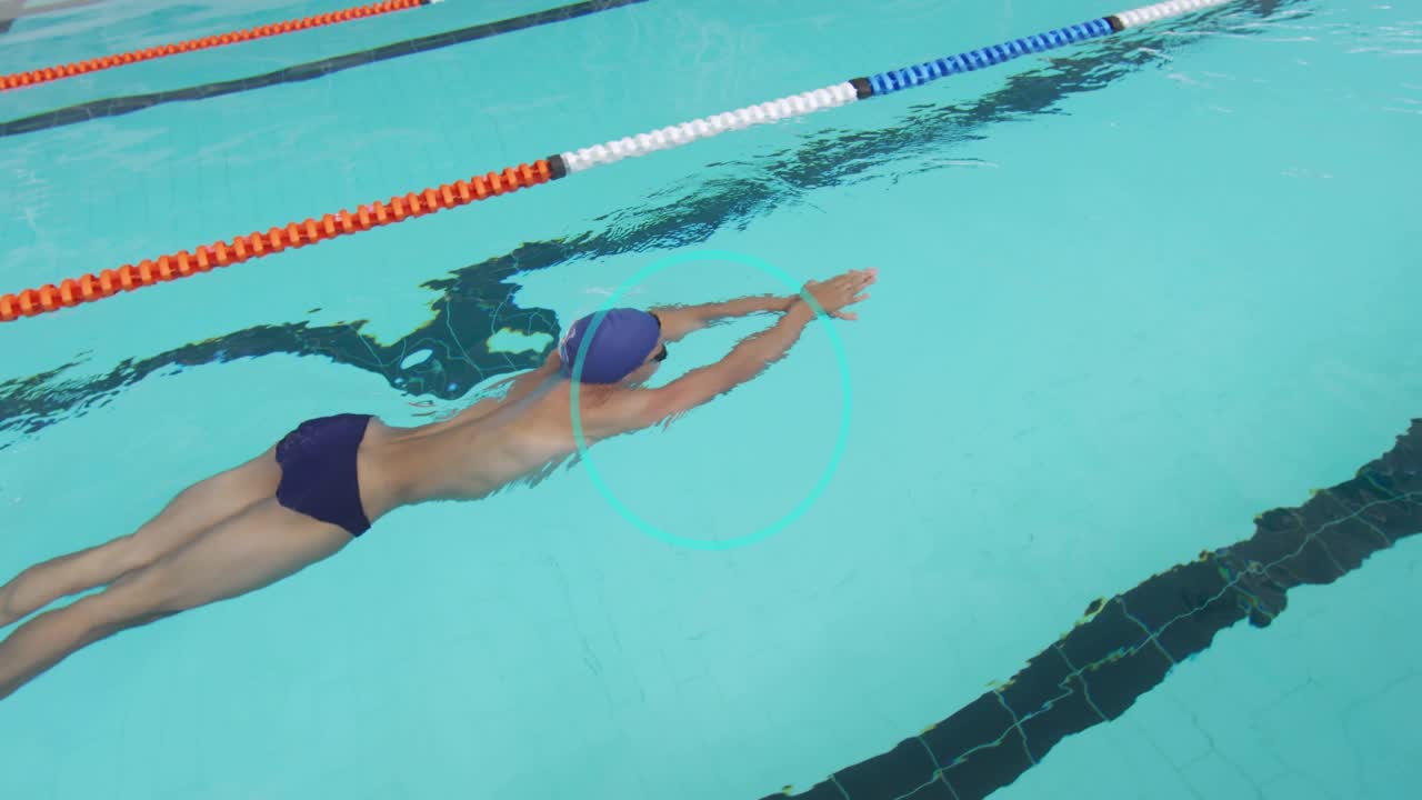 Male swimmer pushing off pool wall doing crawl with breathing for sports training beside lane ropes