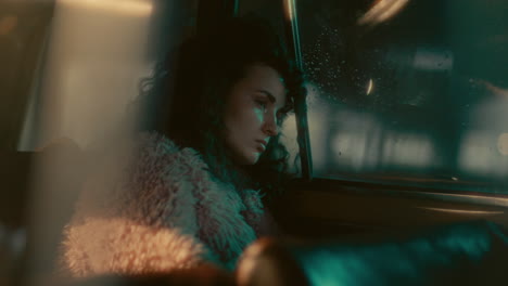 melancholic woman sitting in dimly lit car with rain-streaked window