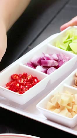 manos montando ingredientes tradicionales de envoltura de hojas tailandesas en la mesa