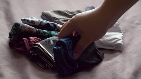 los hombres usan sus manos para doblar la ropa interior masculina para mantenerla organizada y fácil de guardar y usar