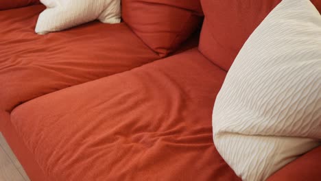 primer plano de un sofá rojo con almohadas blancas