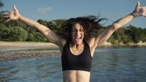 retrato de mujer caucásica gritando y sonriendo, playa en segundo plano, emociones reales no afectadas