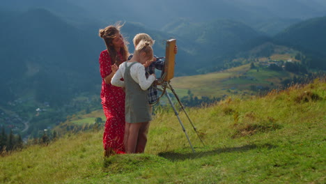happy family drawing mountains outdoor. painter and kids creating picture.
