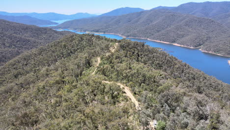 Langsam-Bewegte-Hohe-Drohnenaufnahme,-Die-Aus-Bäumen-Auftaucht-Und-Das-Blaue-Wasser-Der-Berge-In-Der-Nähe-Des-Lake-Eildon,-Victoria,-Australien,-Zeigt