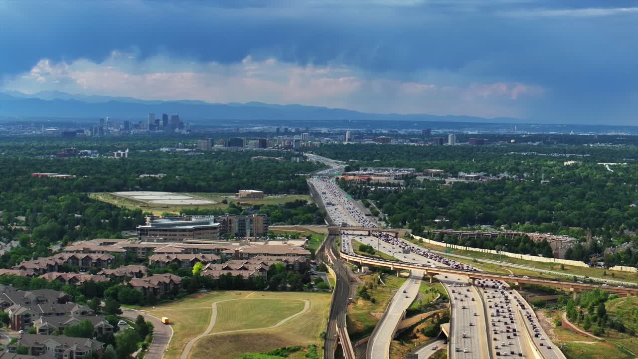 Downtown Denver interstate i25 traffic Denver Tech Center Centennial cityscape aerial drone Colorado sunny blue sky clouds Lone Tree Aurora RTD lightrail Front Range Rocky Mountains pan left motion