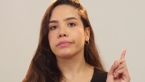 close up of woman saying no and gesturing at the camera
