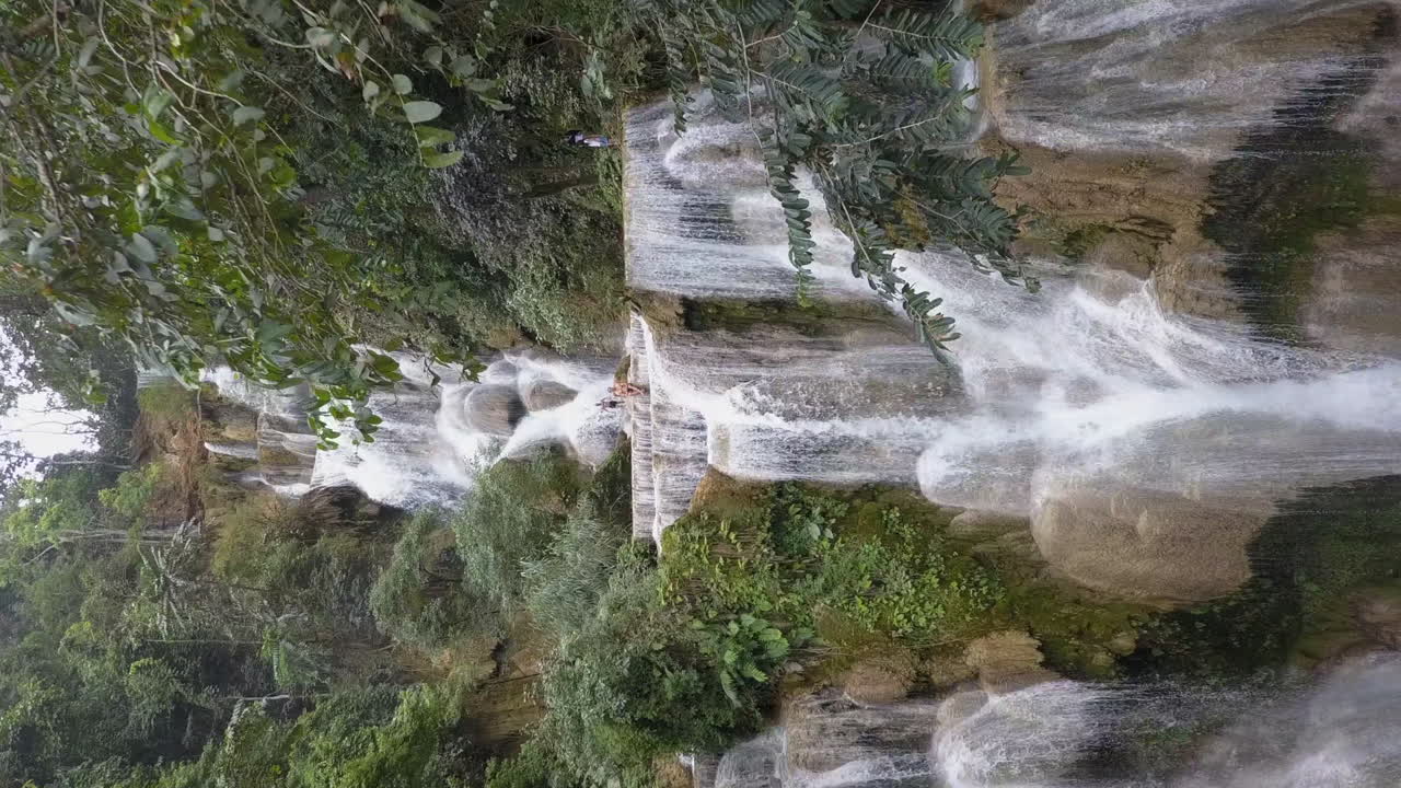 retiros aéreos de la cascada de la selva montañosa a través de los árboles en laos