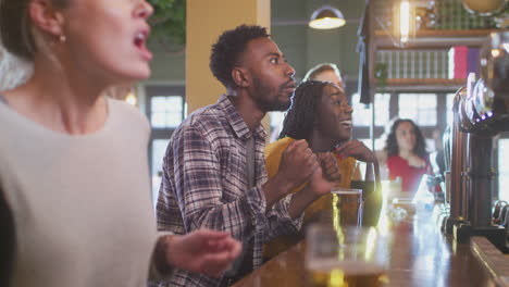 Grupo-De-Clientes-Decepcionados-En-Un-Bar-Deportivo-Viendo-Un-Evento-Deportivo-En-Televisión-Mientras-El-Equipo-Pierde