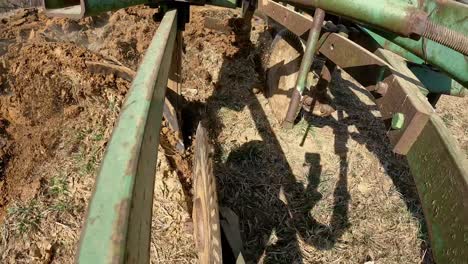 close up on disc and chisel of plow as the soil is cut and turned