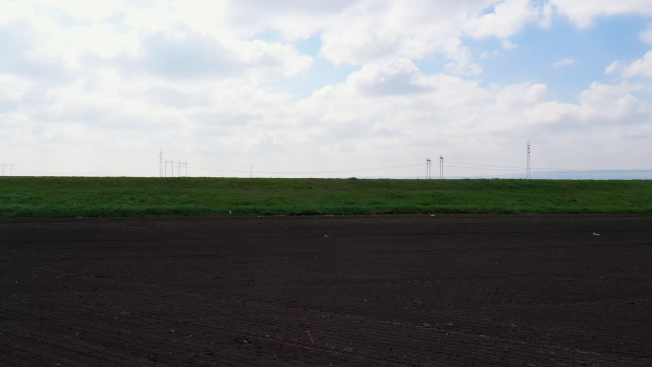 경작된 풍경을 가로지르는 고속도로에서 자동차의 드론 샷