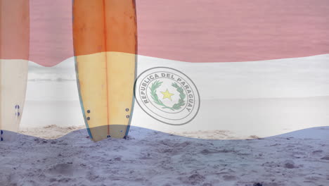 surfboards standing on sandy beach over paraguay flag animation