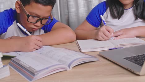 children studying together at a desk