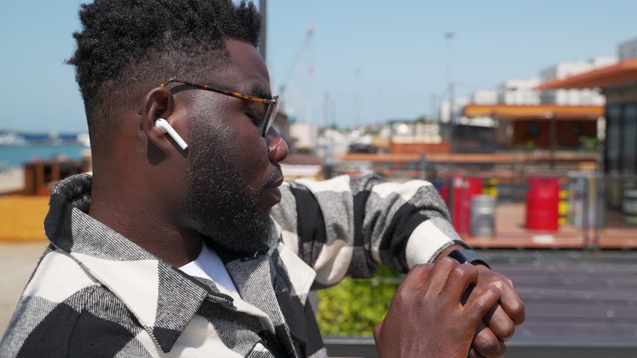 hombre comprobando reloj inteligente al aire libre