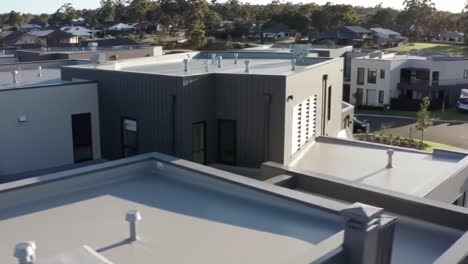 aerial view reveals contemporary rooftops of residential buildings in a quiet suburban area.