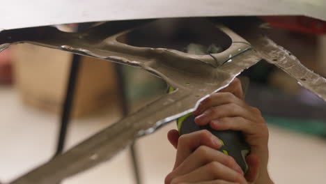 close up of worker hand holding grinding disc power tool to cut through metal, causing sparks, 4k