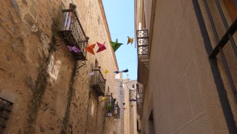 Cáceres-Old-Town-winding-alleyway,-view-of-top-facades,-Spain