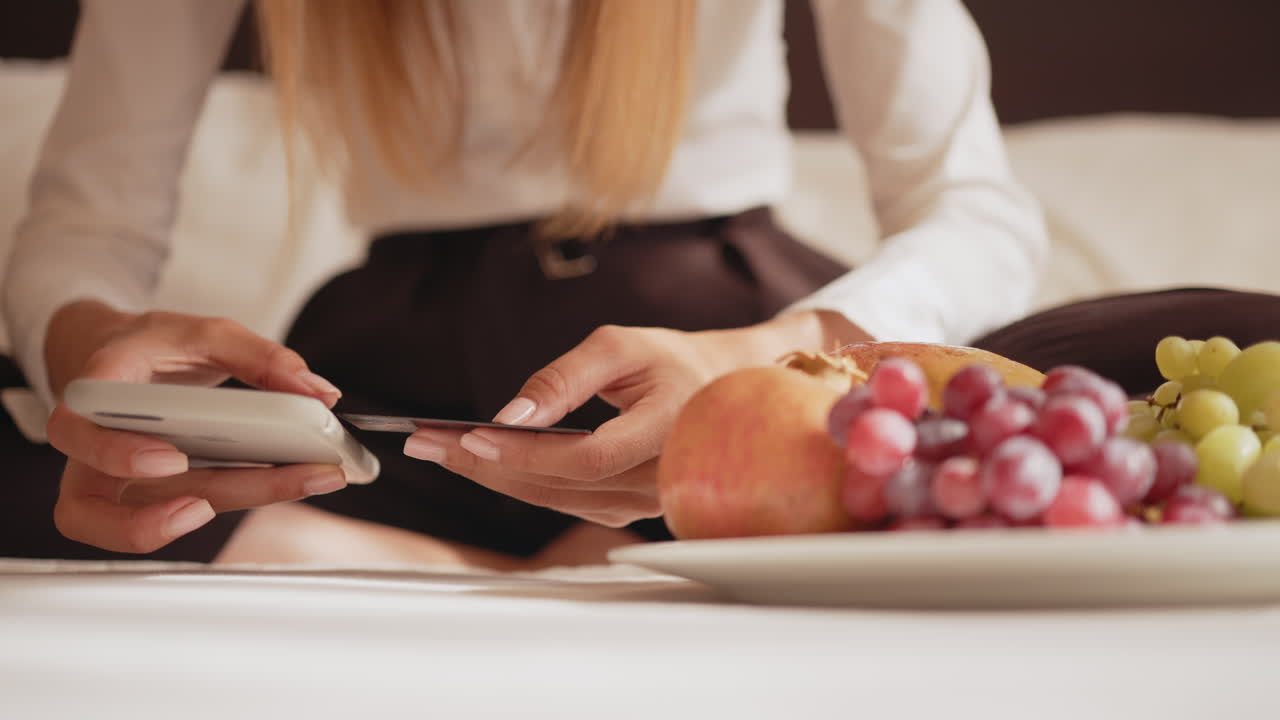 mujer usando pago móvil en la habitación del hotel
