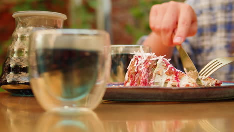 person eating cake outdoors in a cafe