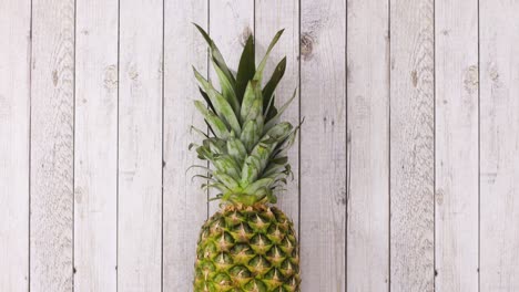 fresh organic pineapple rolling in place on wooden theme. stop motion
