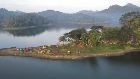 Luftaufnahme,-Schöne-Aussicht-Auf-Den-Sermo-Stausee-Am-Morgen-Zwischen-Den-Hügeln-Und-Touristen,-Die-Am-Rande-Des-Stausees-Campen