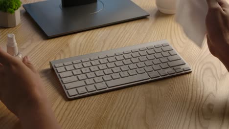 cleaning a keyboard at a home office desk