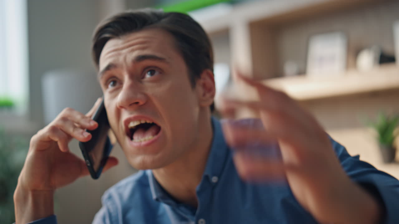 un tipo enojado gritando desde el teléfono móvil. un hombre loco llamando al móvil en un lugar de trabajo.
